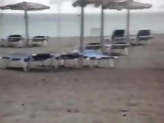Milf sucks and jerks her man's cock at a beach on vacation